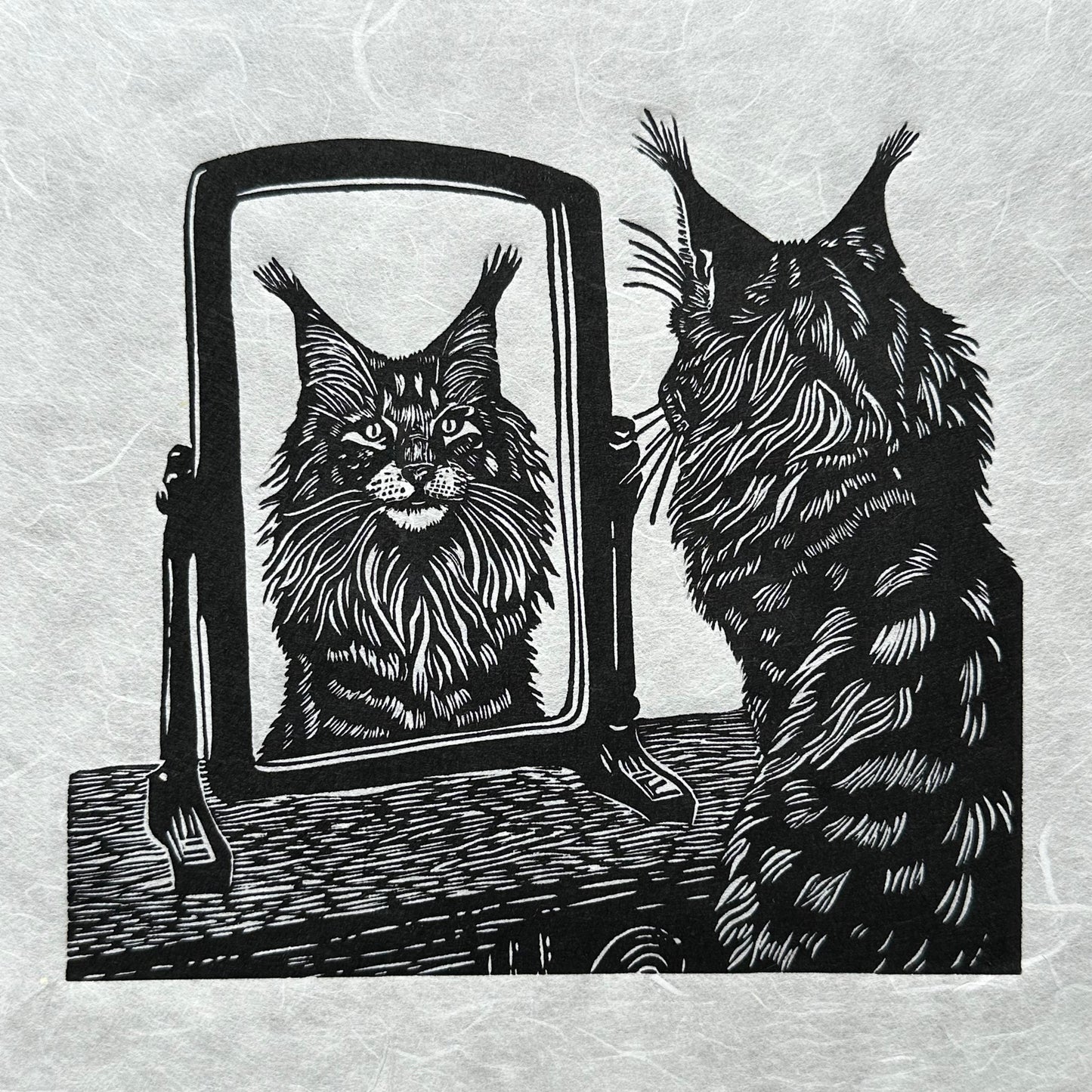 A black and white image of a cat, a maine coon looking at its reflection in a mirror, a perfect gift for cat lovers, wonderful linocut print.