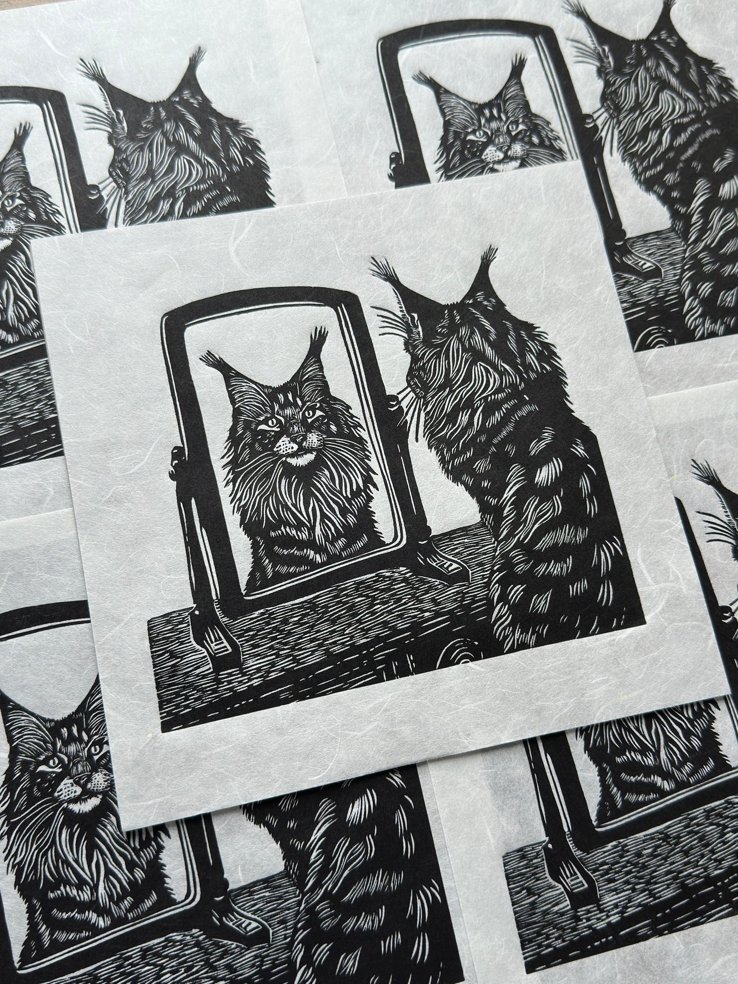 A black and white image of a cat, a maine coon looking at its reflection in a mirror, a perfect gift for cat lovers, wonderful linocut print.